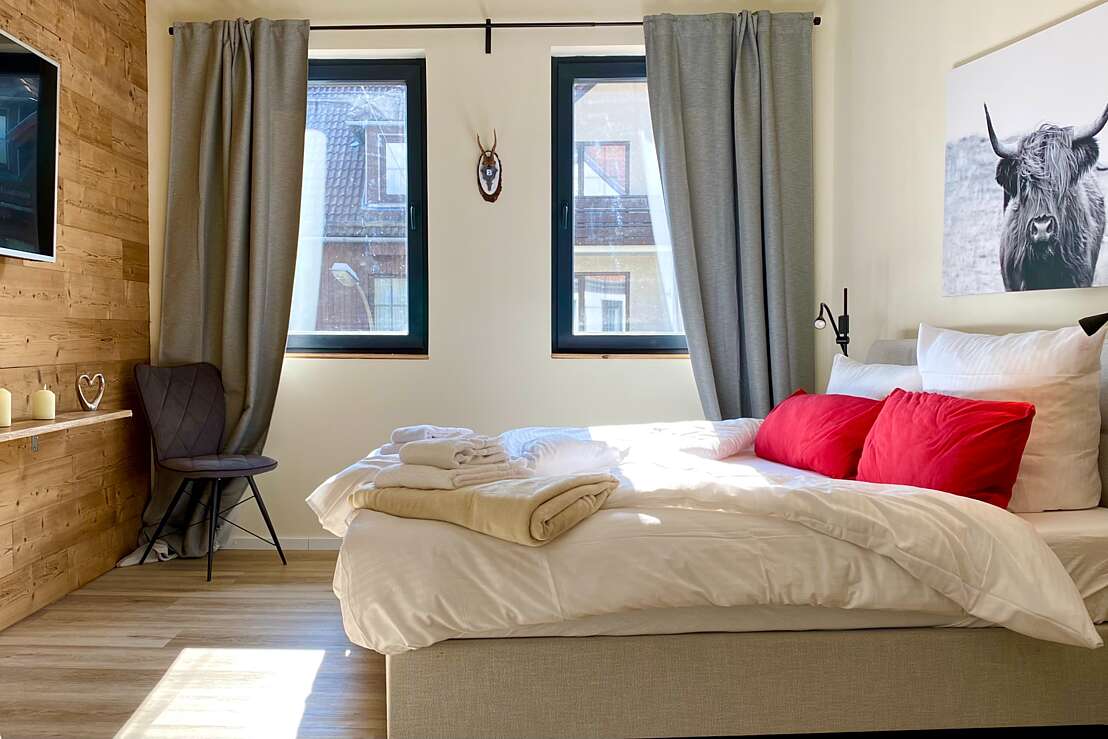 App 3 - Schlafzimmer mit Boxsprinbett und großem Smart-TV