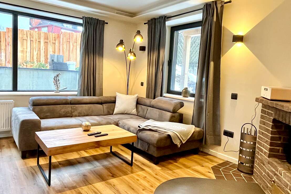 App 8 - Wohnzimmer mit Couch und offenem Kamin